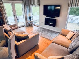 A living room with a television and fireplace at O7 in Abersoch