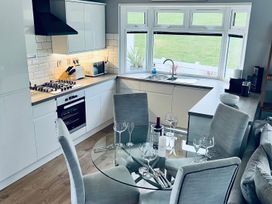 A kitchen with a round dining table and chairs at O7 in Abersoch