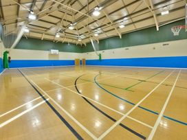A sports hall with court lines and a basketball hoop at O7 in Abersoch