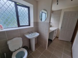 A bathroom with a toilet, sink, and mirror at the property in location