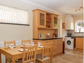 A kitchen with a dining table and chairs at Halsdon Avenue in Exmouth