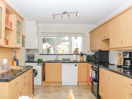 A kitchen with cabinets, sink and appliances at Halsdon Avenue in Exmouth