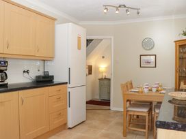 A kitchen with a fridge and table at Halsdon Avenue, Exmouth