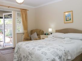 A bedroom with a bed and an armchair at Halsdon Avenue in Exmouth