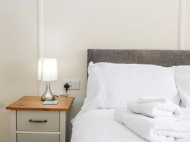 A bedroom with a bed, lamp, and nightstand at Halsdon Avenue Exmouth