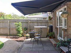 A garden with a table and chairs under an awning at Halsdon Avenue Exmouth