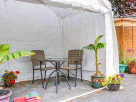 An outdoor area with a table and chairs under a tent at Halsdon Avenue in Exmouth