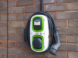 An electric vehicle charging station mounted on a wall at Halsdon Avenue in Exmouth