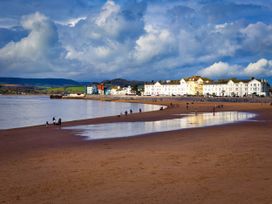 A beach with water and buildings in the background at Halsdon Avenue, Exmouth