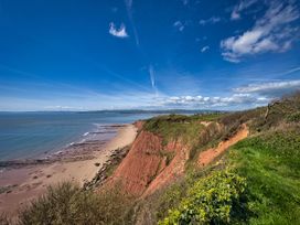 A view of cliffs and beach under a blue sky at Halsdon Avenue in Exmouth