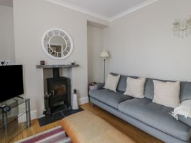 A living room with a sofa and fireplace at Arosfa New Quay