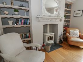 A living room with a bookshelf and a fireplace at Arosfa New Quay