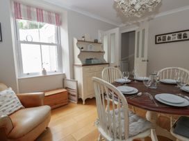 A dining room with a table set for a meal at Arosfa New Quay