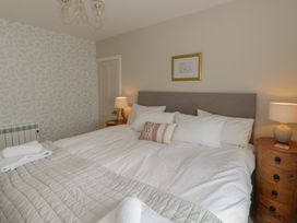 A bedroom with a bed and bedside lamps at Arosfa New Quay