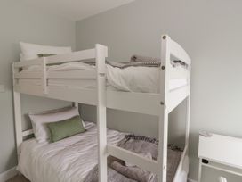 A bedroom with a bunk bed and bedding at Arosfa New Quay
