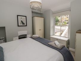 A bedroom with a bed and wardrobe at Arosfa New Quay