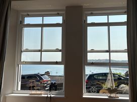 Two windows with ocean view and decorative items in a living room at Arosfa New Quay