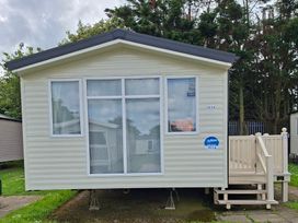 A cabin with windows and a deck at Primrose Valley, Amara's Retreat Filey