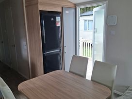 A kitchen with a fridge and table at Primrose Valley, Amara's Retreat in Filey