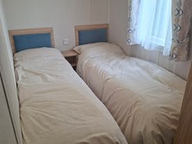 A bedroom with two single beds at Primrose Valley, Amara's Retreat in Filey