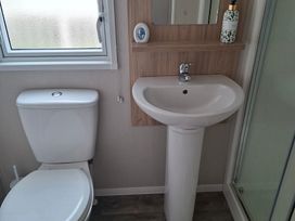 A bathroom with a sink and toilet at Primrose Valley, Amara's Retreat in Filey