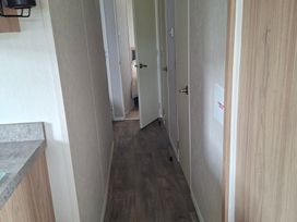A hallway with doors on both sides at Primrose Valley, Amara's Retreat in Filey