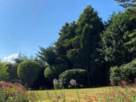A garden with trees and flowers at The White House in Okehampton