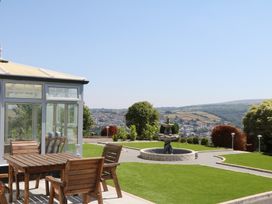 A garden with a conservatory and an outdoor table at The White House in Okehampton