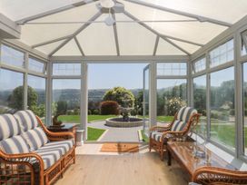A conservatory with seating and a view of a garden at The White House Okehampton
