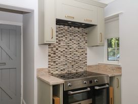 A kitchen with a cooker and cabinet at The White House in Okehampton