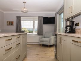 A kitchen with a window and an armchair at The White House in Okehampton