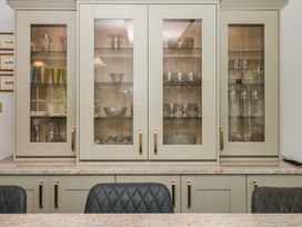 A glass cabinet with crystal items and glasses at The White House Okehampton