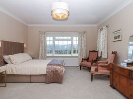 A bedroom with a bed and armchair at The White House in Okehampton