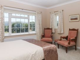 A bedroom with a bed and two chairs at The White House in Okehampton