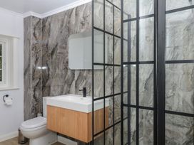 A bathroom with a sink, toilet, mirror and shower at The White House in Okehampton