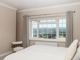 A bedroom with a bed, window, and chair at The White House in Okehampton