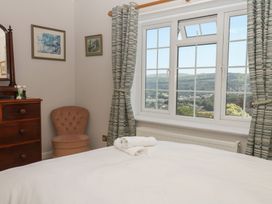A bedroom with a bed and window at The White House in Okehampton