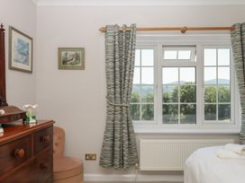 A bedroom with a window and curtains at The White House in Okehampton