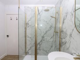 A bathroom with a shower and marble walls at The White House in Okehampton
