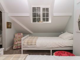 A bedroom with beds and an armchair at The White House in Okehampton