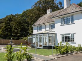 A house with a conservatory and fountain in the garden at The White House in Okehampton