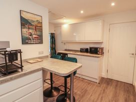 A kitchen with bar stools and kitchen appliances at Hidden Gem