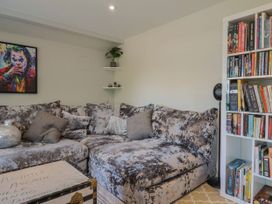 A living room with a sofa and bookshelf at Mayflower Cottage in Lyme Regis
