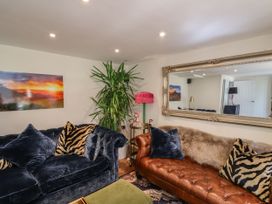 A living room with sofas and a plant at Mayflower Cottage in Lyme Regis