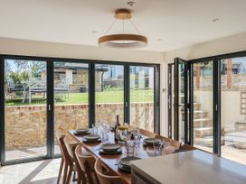 A dining room with a table set for meals at Mayflower Cottage in Lyme Regis