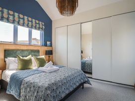 A bedroom with a bed and nightstand at Mayflower Cottage in Lyme Regis