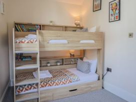A bedroom with a bunk bed and shelves at Mayflower Cottage in Lyme Regis