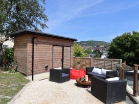 A garden with a wooden shed and outdoor seating at Mayflower Cottage in Lyme Regis