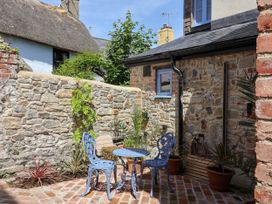 A garden with a blue table and chairs at Mayflower Cottage in Lyme Regis