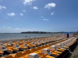A row of pedal boats on the beach at Mayflower Cottage in Lyme Regis